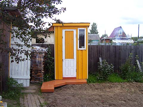 Дачный туалет в ярко желтом окрасе. Удобные мостки при входе.